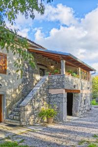 a stone house with a porch and a balcony at Apartman studio Baladur in Roč