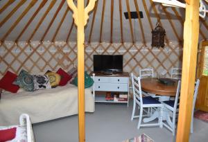 um quarto com uma cama e uma mesa numa tenda em The Yurt in Cornish woods a Glamping experience em Penzance