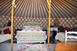 um quarto com uma cama numa tenda em The Yurt in Cornish woods a Glamping experience em Penzance