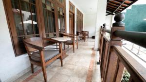 uma fila de cadeiras e mesas num alpendre em HOTEL SAPTA GRIA em Jetis