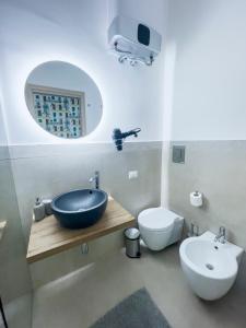 Un baño con lavabo, inodoro y espejo. en Saint Barth Guest House - Steps Loft in Bari, en Bari
