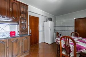 een keuken met een tafel en een witte koelkast bij Best Houses 16 - Casa do Centro in Peniche