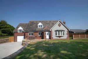 a large brick house with a driveway in a yard at The Breckland at Sugar Lane Farm in Bollington