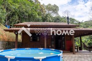 eine Villa mit einem Pool vor einem Haus in der Unterkunft Casa com área de lazer e vista para as montanhas in Aguas Mornas