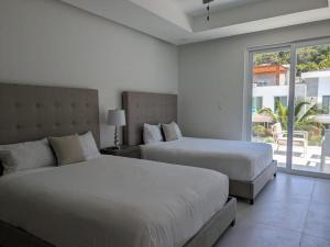 1 dormitorio con 2 camas y ventana grande en Dolphin Villa #09, en West Bay