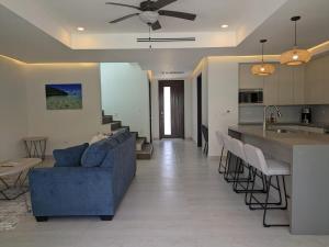 a living room with a blue couch and a kitchen at Dolphin Villa #09 in West Bay