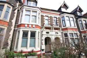 una vieja casa de ladrillo con adornos blancos en Cozy 1 Bedroom Apartment | WIFI en Cardiff