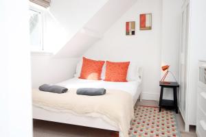 a bedroom with a white bed with orange pillows at Cozy 1 Bedroom Apartment | WIFI in Cardiff