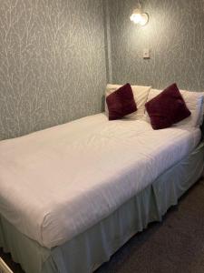 a bed with two pillows on it in a bedroom at Iona Hotel in Blackpool