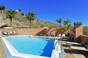 einen Pool mit Palmen und einem Berg in der Unterkunft Ferienhaus für 4 Personen ca 120 qm in El Salobre, Gran Canaria Südküste Gran Canaria in Maspalomas