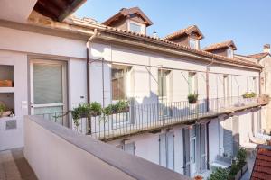 an apartment building with potted plants on the balcony at 21 Lake Sweet Home in Como