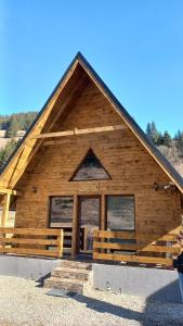 a log cabin with a gambrel roof at ALI HOUSE in Poiana Fagului