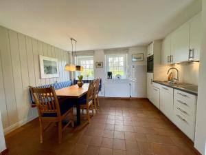 eine Küche und ein Esszimmer mit einem Tisch und Stühlen in der Unterkunft Altes Friesenhaus Scheune in Morsum