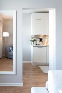 a living room with white cabinets and a kitchen at City Apartment Snowberry in Rovaniemi +9 photos