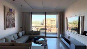 - un salon avec un canapé et une grande fenêtre dans l'établissement Superbe appartement de luxe a l'hivernage marrakech, à Marrakech