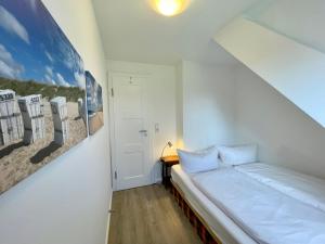 ein Schlafzimmer mit einem Bett und einem Bild an der Wand in der Unterkunft Altes Friesenhaus Scheune in Morsum