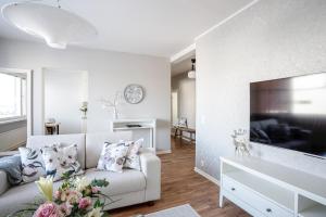 a living room with a couch and a large television at City Apartment Snowberry in Rovaniemi