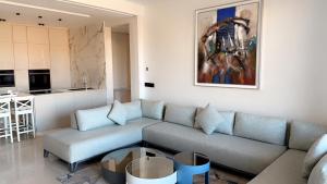 ein Wohnzimmer mit einem Sofa und einer Küche in der Unterkunft Superbe appartement de luxe a l'hivernage marrakech in Marrakesch