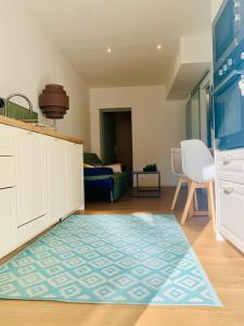 a living room with a blue rug on the floor at F2 port de canet in Canet-en-Roussillon