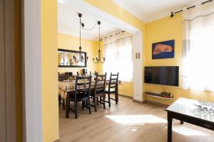 a dining room with yellow walls and a table and chairs at Vincent's House in Barcelona