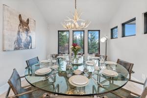 une salle à manger avec une table et des chaises en verre dans l'établissement Whitefish Lookout Estate- 1 Arce Property with Panoramic Views of Whitefish Lake, à Whitefish