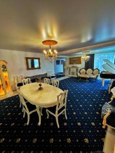 uma grande sala de estar com mesa e cadeiras em Prive Villa em Durleşti