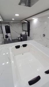 een badkamer met een wit bad met zwarte handvatten bij Casa con ambiente familiar- Jacuzzi privado in Armenia