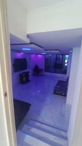 una habitación vacía con luces moradas en una habitación en Casa con ambiente familiar- Jacuzzi privado en Armenia