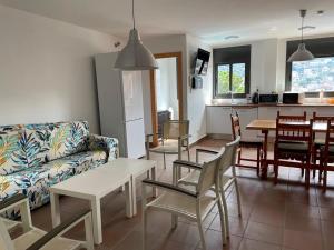 uma sala de estar com um sofá, uma mesa e cadeiras em Habitaciones en Villa Coliving Villa Vistas em San Fausto de Campcentellas