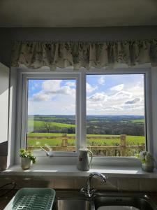 ein Küchenfenster mit Blick auf die Landschaft in der Unterkunft Meadow cottage in Haverfordwest