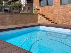 uma piscina em frente a um edifício de tijolos em Habitaciones en Villa Coliving Villa Vistas em San Fausto de Campcentellas