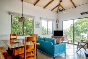 ein Wohnzimmer mit einem blauen Sofa und einem Tisch in der Unterkunft Canto Del Mar #13 in Dominical