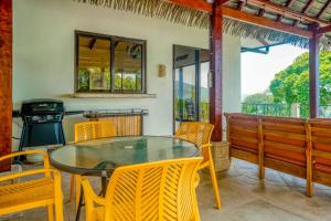 a dining room with a table and chairs and a grill at Canto Del Mar #13 in Dominical