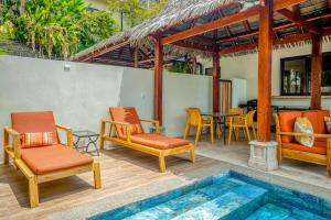 een resort met een zwembad en stoelen en een tafel bij Canto Del Mar #13 in Dominical