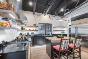 a kitchen with black cabinets and a island with a table at Whitefish Suncrest Charm- Newly Build Modern Townhouse w Pool Table andPet Friendly! in Whitefish