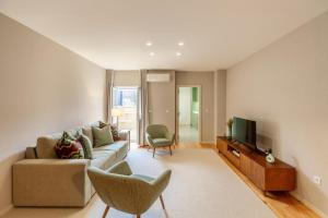ポルトにあるSavvy Signature Apartmentsのソファとテレビのあるリビングルーム