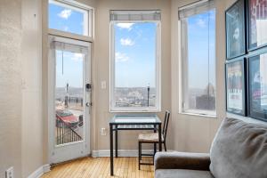 a living room with a table and large windows at Charming Studio-Panoramic View-Your Pittsburgh Sanctuary in Pittsburgh