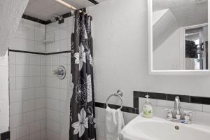 a bathroom with a sink and a shower curtain at Charming Studio-Panoramic View-Your Pittsburgh Sanctuary in Pittsburgh