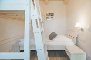 ダゲビュルにあるFerienhaus Seesternの二段ベッド2組とはしごが備わる客室です。