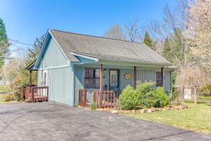 une maison bleue avec une véranda et une allée. dans l'établissement Pet-Friendly Byrdstown Cottage with Deck and Fire Pit!, à Byrdstown