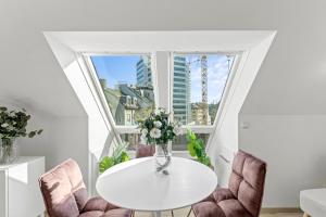 una mesa blanca y sillas con un jarrón de flores en Designer Apartments Asaria en Viena