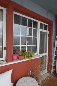- une fenêtre avec des plantes en pot et une chaise dans la chambre dans l'établissement tania's view, à Kastoria