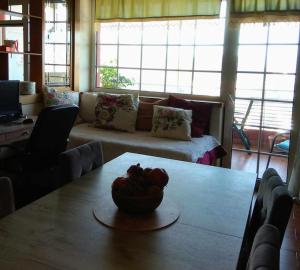 una sala de estar con una mesa con un bol de fruta. en tania's view, en Kastoria