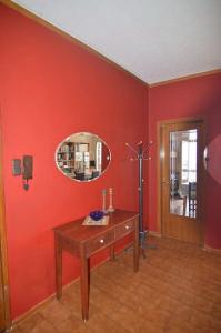 Cette chambre rouge comprend une table en bois et un miroir. dans l'établissement tania's view, à Kastoria