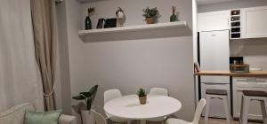 una cucina con tavolo bianco e tavolo e sedie bianchi di Machico Heart Suites a Machico