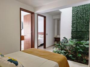- une chambre avec un lit et un mur vert dans l'établissement VILLA NATURAL, à Fómeque