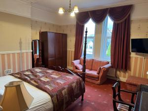um quarto com uma cama, um sofá e uma televisão em The Chetwynde em Barrow in Furness