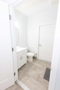 a white bathroom with a toilet and a sink at Modern & Cozy 2 - Bedroom gem mins from NYC in Jersey City
