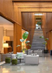 un hall avec des canapés et des plantes ainsi qu'un escalier dans l'établissement Inspira Liberdade Boutique Hotel, à Lisbonne