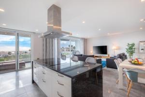 Casa Chloe Luxury Ocean View Apartment في لاغوس: مطبخ وغرفة معيشة مطلة على غرفة معيشة